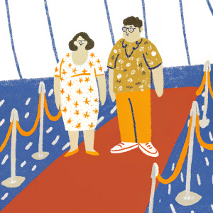 Raini Rodriguez and Rico Rodriguez at award show. Purple carpet with abstract designs. Raini in floral print dress, Rico in camo shirt and red sneakers.