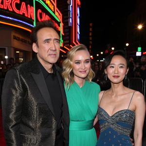 Nicolas Cage, Diane Kruger, and Alice Kim at a film premiere. Neon lights and bustling crowd in the background.