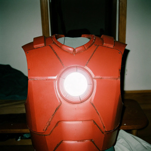 Tony Stark's glowing chest plate. Dark metallic surface against dimly lit room