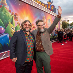 Jack Black and Seth Rogen at the Super Mario Bros. movie premiere. Red carpet event with colorful background and enthusiastic crowd.