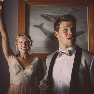 Emily Osment and Jimmy Tatro at the 2015 Shorty Awards, dressed formally. Whale-themed backdrop, black-tie event.