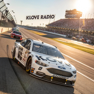 White and black Ford Fusion NASCAR race car with KLOVE Radio and Thrivent Financial logos, racing on a sunny day at Talladega Superspeedway