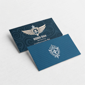Business cards for Rodrigo Guerra Tattoo Studio. Blue background. Emblematic design. Email and contact info visible.