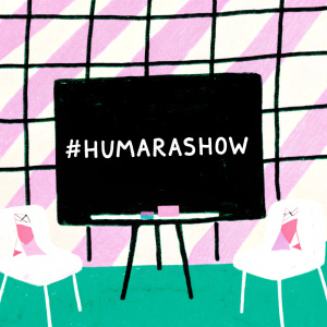 Setup for a modern event. Large display board with #HumaraShow hashtag. Indoors, contemporary design with black, white, and purple checkered pattern. English and Indian script text visible.