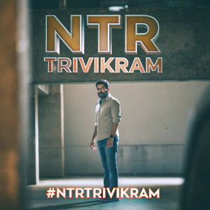 Promotional image for the movie 'NTR: Trivikram'. Trivikram, the director, standing center stage against a blurred background. The movie title, release date, and social media hashtag '#NTRTrivikram' are prominently displayed.