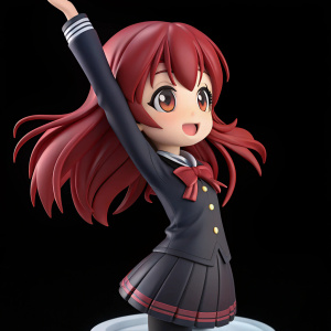 3D figurine of Atsuko Kagari from Studio Trigger. Lively pose, arms raised, head tilted. Rich red color, dark texture, against black background.