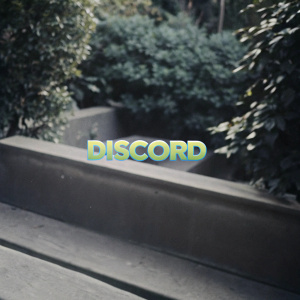A sleek banner for Discord featuring the Discord logo in vibrant green hues. Set against a backdrop of lush greenery, the word 'Discord' prominently displayed at the center.