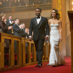 Chiwetel Ejiofor and Jessica Alba at the Academy Awards. Chiwetel, African descent, wearing black tuxedo, Jessica, white dress. Applause from audience