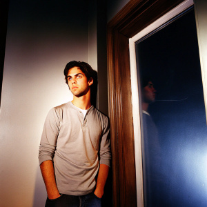 Milo Ventimiglia in a candid photo shoot. Intense gaze. Dark studio background with soft lighting.
