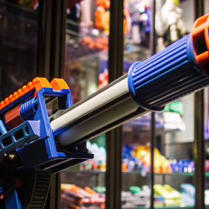 Blue and orange Nerf Elite Disruptor blaster. Detailed design, long barrel. Background is vibrant toy store display