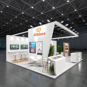 Sophisticated booth design at CES trade show. Alibaba showcase featuring sleek displays and digital screens. White and modern setup with seating area. Prominent signage highlighting Alibaba website and trade app. Interactive and welcoming atmosphere amidst bustling event