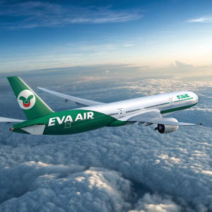 Boeing 777 aircraft of EVA Air. Green and white livery. In mid-flight over dense cloud cover. Tail has EVA Air logo.