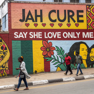 A vibrant mural depicting lyrics from 'Say She Love Only Me' by Jah Cure. Painted on the side of a bustling street.