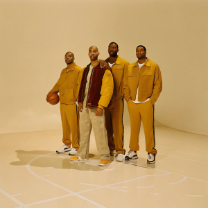 A group photo of the Los Angeles Lakers players and coaching staff. They are standing in the Staples Center. Everyone is in Lakers jerseys and team jackets.