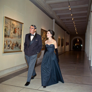 Gregory Peck and Veronique Peck strolling along the elegant corridors of the Norton Simon Museum in Pasadena, California. Gregory, wearing a tailored suit, while Veronique is adorned in an elegant evening gown.