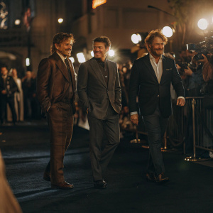Johnny Depp, Orlando Bloom, and Jerry Bruckheimer attending a Hollywood premiere. Black carpet, paparazzi flashing