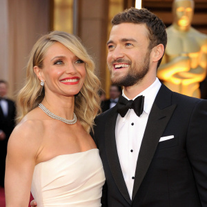 Cameron Diaz and Justin Timberlake at the Academy Awards. Both in black and white formal wear. Cameron with a radiant smile and blonde hair styled in waves. Justin with a close-cropped beard and curly hair. They pose formally, standing close together, amidst red carpet excitement.