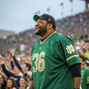 Jerome Bettis in his green Notre Dame Fighting Irish jersey. Stadium background, crowd cheering.