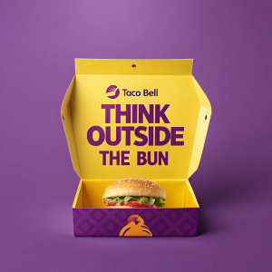 Purple background, Taco Bell promotional box with 'Think Outside The Bun' written on it.