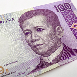 Philippine currency, a 100 peso bill, features a portrait of Emilio Aguinaldo. The bill has a vibrant purple and white color scheme.