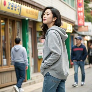 Shin Se-kyung, Korean actress, in casual attire. Gray hoodie and jeans. Background: lively street scene.