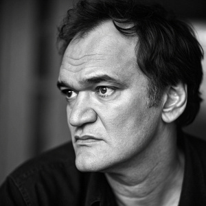 Quentin Tarantino in a gritty black and white interview photo for a new film magazine. No background details, focused on his face.