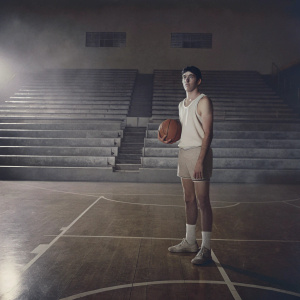 Ty Jerome, dressed in a Lakers jersey, standing alone on an empty basketball court.