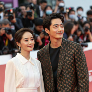 Actors Kim Hyo-jin and Kim Kang-Woo at the Seoul International Film Festival. Numerous photographers and audience members in the background. Kim Hyo-jin in white blouse, Kim Kang-Woo in patterned jacket.