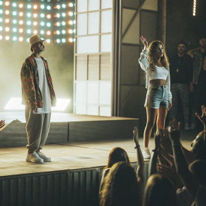 Justin Bieber and Shanina Shaik at a music festival. Concert stage in background, crowd cheering