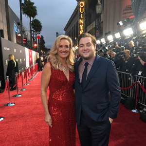 Marcy Wudarski and Michael Gandolfini at a glitzy Hollywood premiere. Posing on a shimmering red carpet.