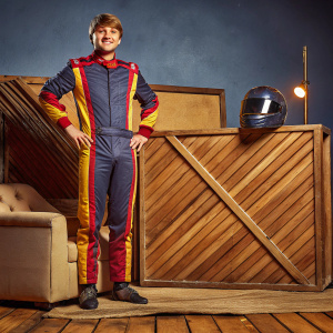 William Byron, young and energetic NASCAR driver, in sleek racing gear. Shot in studio with plain backdrop.