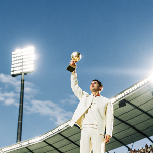 Golden Globe award ceremony. Cristiano Ronaldo holding the trophy. Stadium lights illuminate the venue