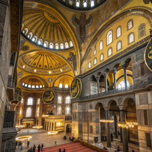 Inside Hagia Sophia, detailed gold mosaics and intricate designs cover walls and ceilings, highlighting grandeur and scale.