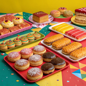 A colorful array of Jollibee pastries displayed on a vibrant tablecloth. The pastries come in different shapes and fillings.