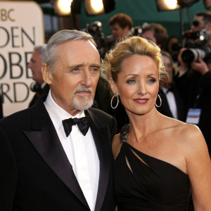 Dennis Hopper and Katherine LaNasa at the Golden Globe Awards. Dennis in black bow-tie formal attire, Katherine in elegant black gown. Crowded venue with flashing cameras