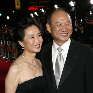 John Woo and Annie Woo Ngau Chun-lung at the Hollywood premiere. Smiling, dressed in formal attire.
