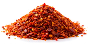 Spicy chili red pepper flakes, chopped, milled dry paprika pile isolated on white