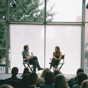 Dax Shepard and Lake Bell at the press junket. Sitting in chairs. Studio audience in background