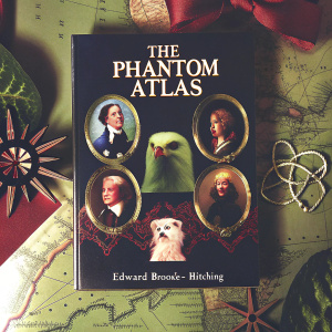 Antique-style map book cover for 'The Phantom Atlas' by Edward Brooke-Hitching. The cover features historical figures, an eagle, portraits, and other historical elements in a mix of brown, green, and red hues.