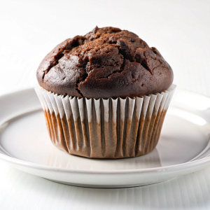 Chocolate muffin on a white plateon white background